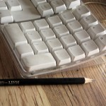 pencil next to a computer keyboard on desk