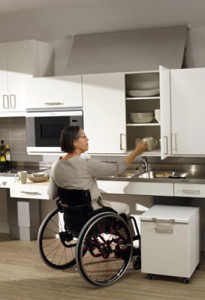 lowered kitchen cabinet accessed by woman in wheelchair