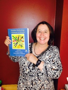 Dr. Willkomm holds up her latest book on assistive technology solutions