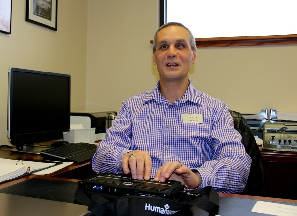 Fred using Braille note at his desk 