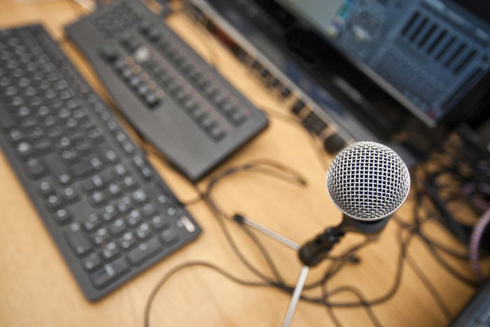 Microphone and computer keyboards on table at television studio