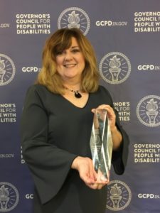 Stacey holding the Champions of Inclusion Award