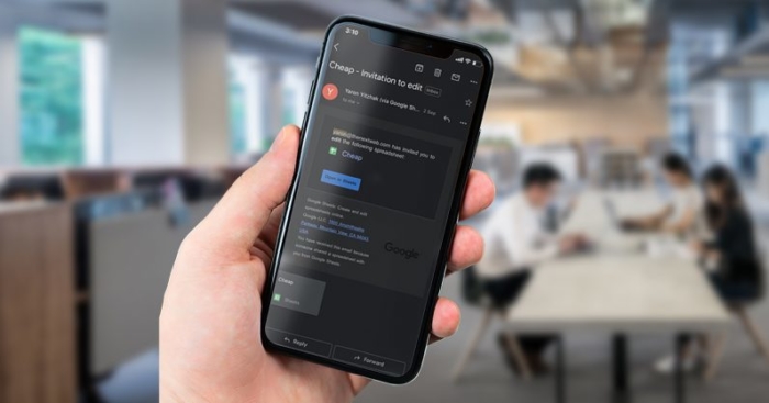 Hand holding smart phone with dark mode