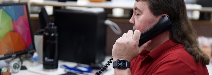 Randy Berg answering phone at his desk