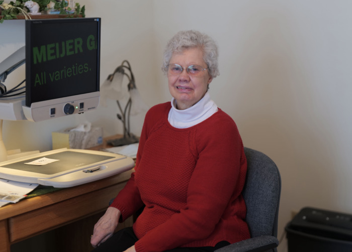 Photo of Candy Sherd sitting beside desktop magnifier