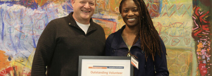 Brian Norton presenting Mela with volunteer of the year certificate