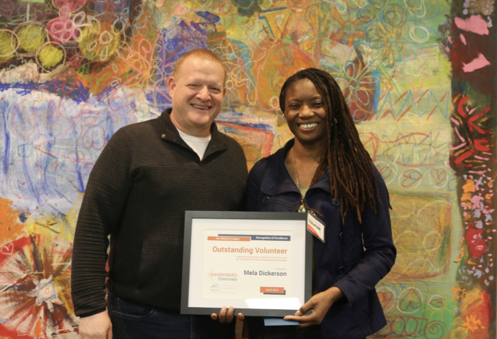 Brian Norton presenting Mela with volunteer of the year certificate