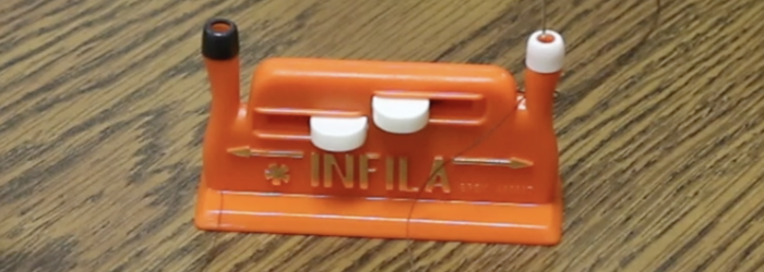 INFILA Automatic Needle Threader sitting on a table